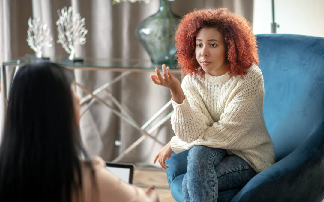 Speaking,with,psychologist.,young,woman,wearing,jeans,and,sweater,speaking